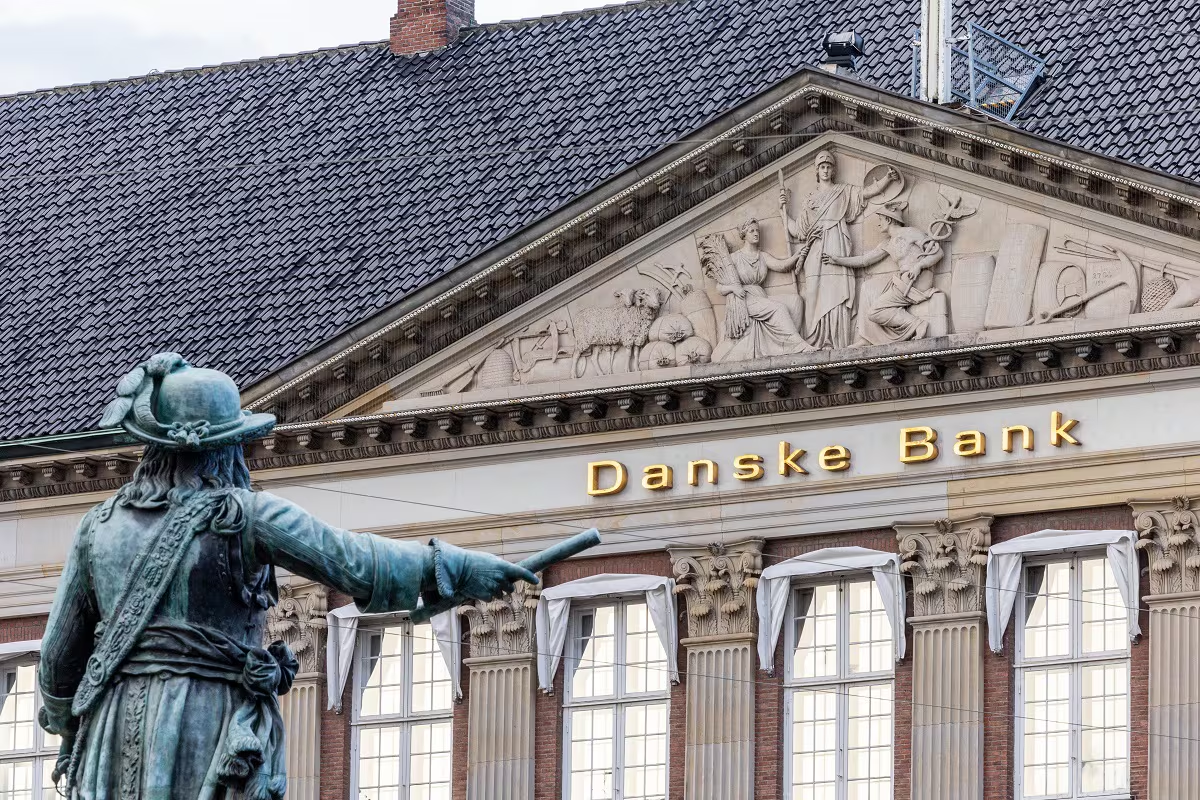 Danske Bank neoclassical facade with gold lettering and a bronze statue in the foreground
